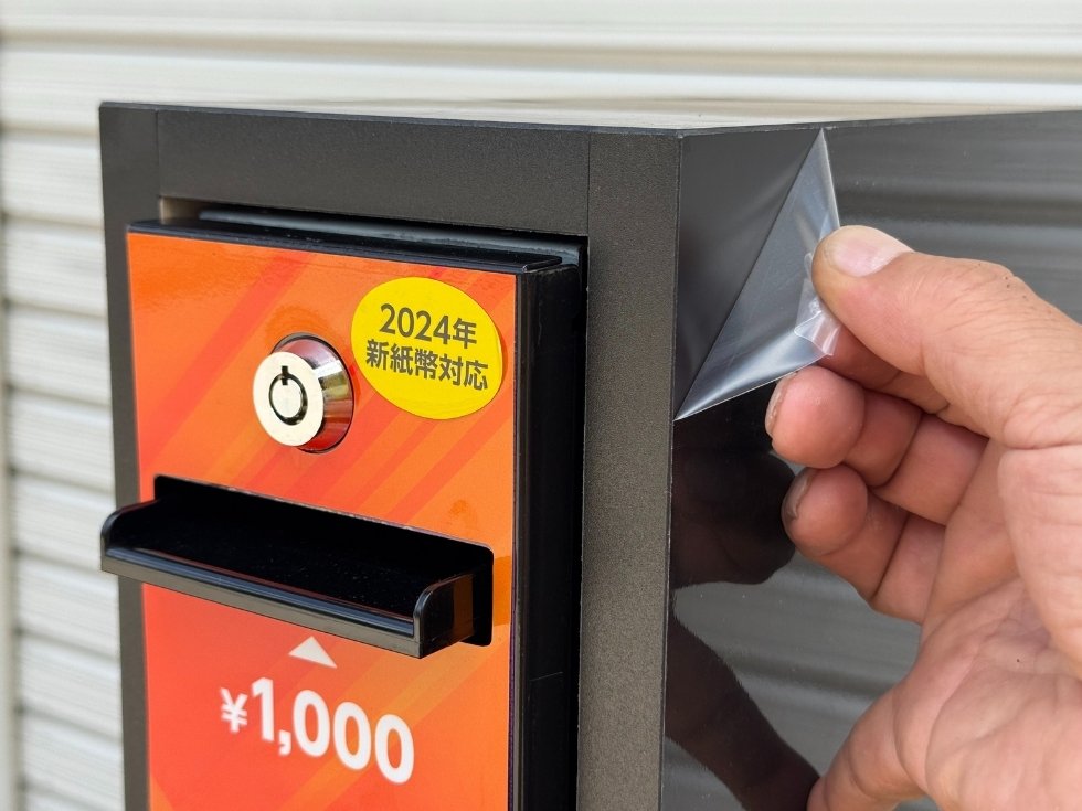 スリム両替機専用キャビネットの保護シールを撮影