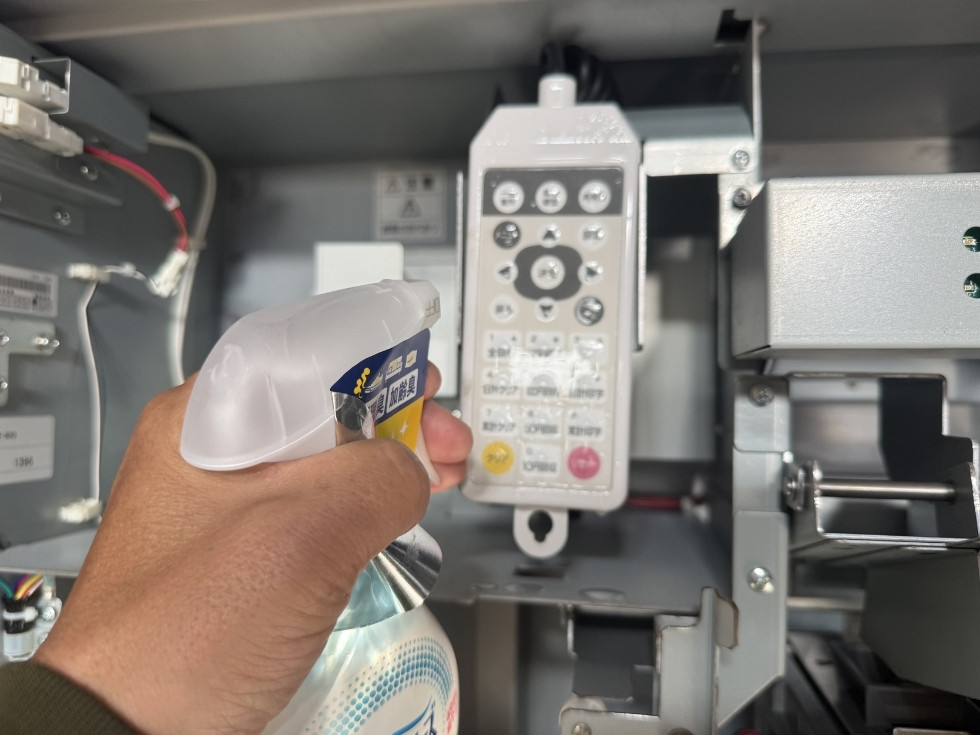 訳あり券売機に付着したニオイをファブリーズで除去してる風景